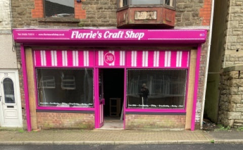 Image shows Florrie's Craft Shop with a pink and white Shop front on a brick building.