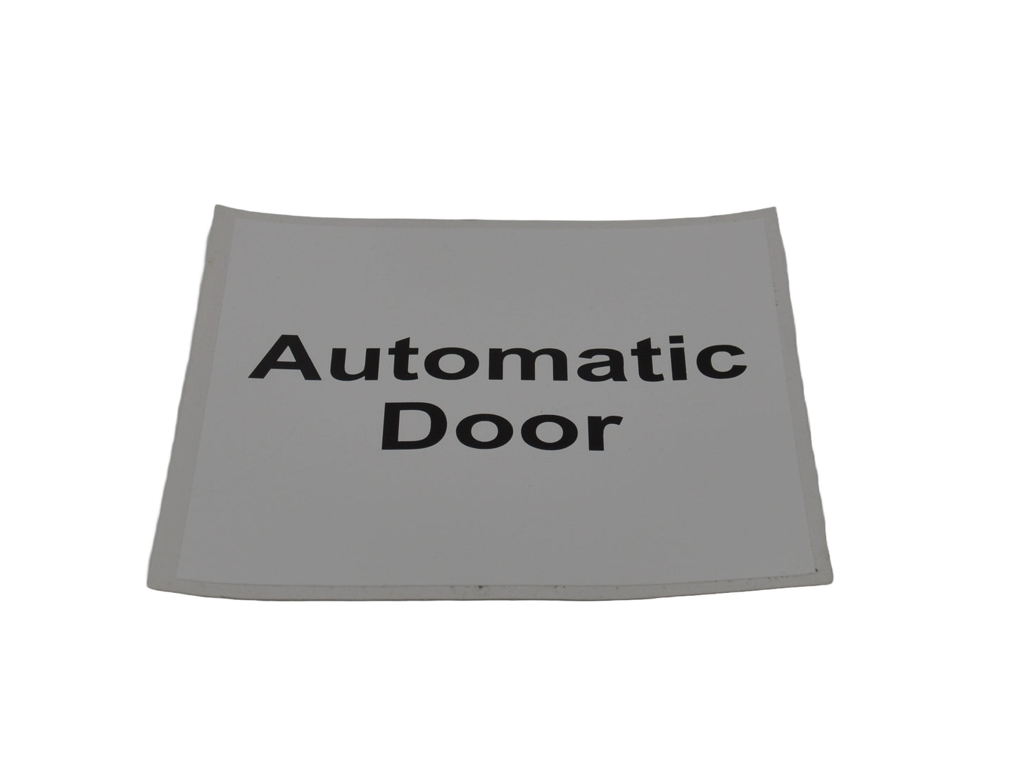 A white self-adhesive automatic door sign with black text, indicating 'Automatic Door' in English. On white background.