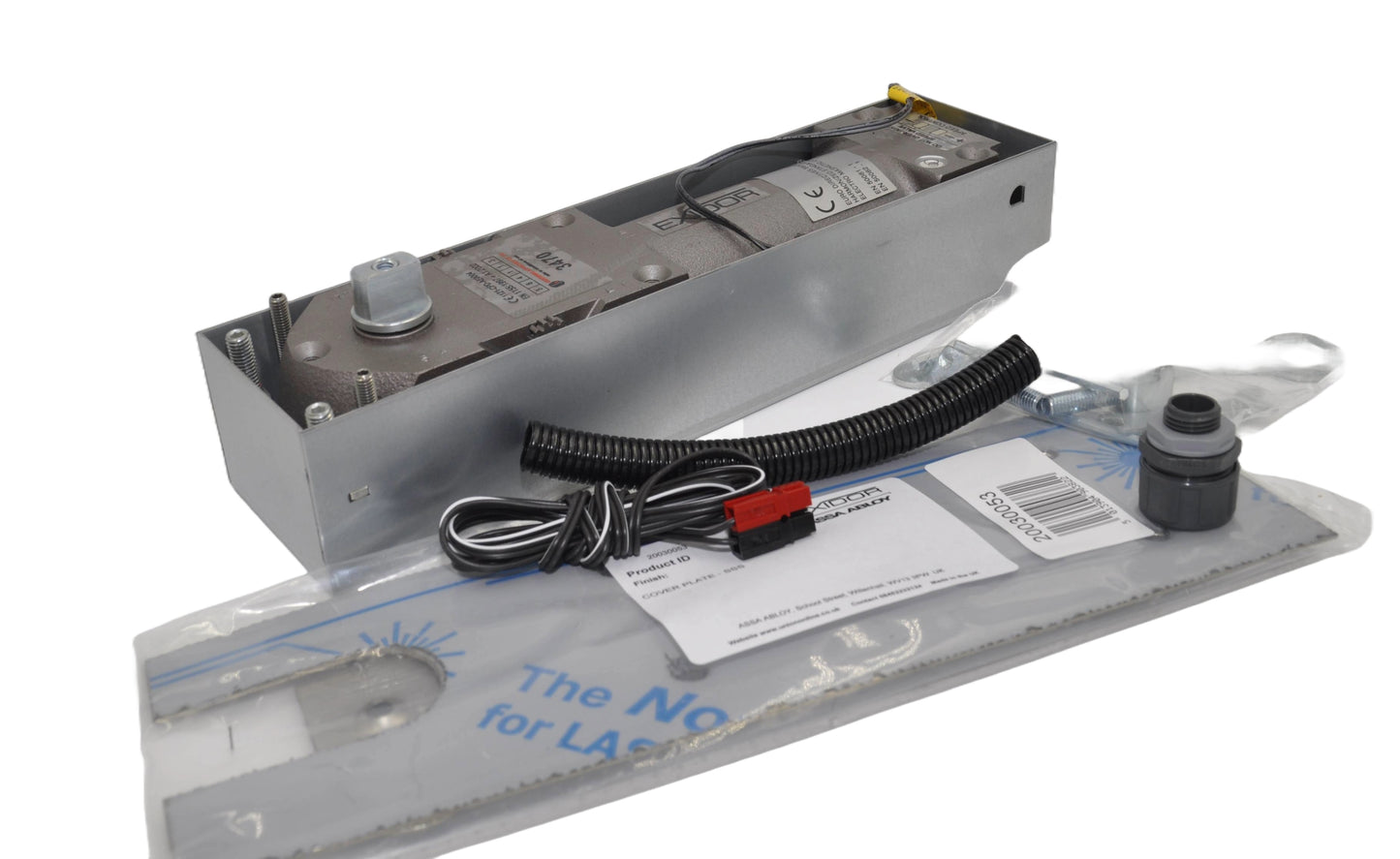 Exidor 3470 EMAG Floor Spring, an electromagnetic hold-open floor closer for heavy-duty doors, showing the mechanism within a metal housing box. There are fixings in clear packaging and wires with a black and red connectors, On a white background.
