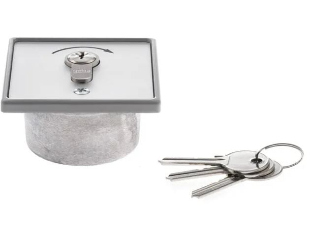 Assa abloy key-switch, a square panel with keyhole,  screw and black arrow pointing right,  3 keys by the side on a keyring, on a white background.