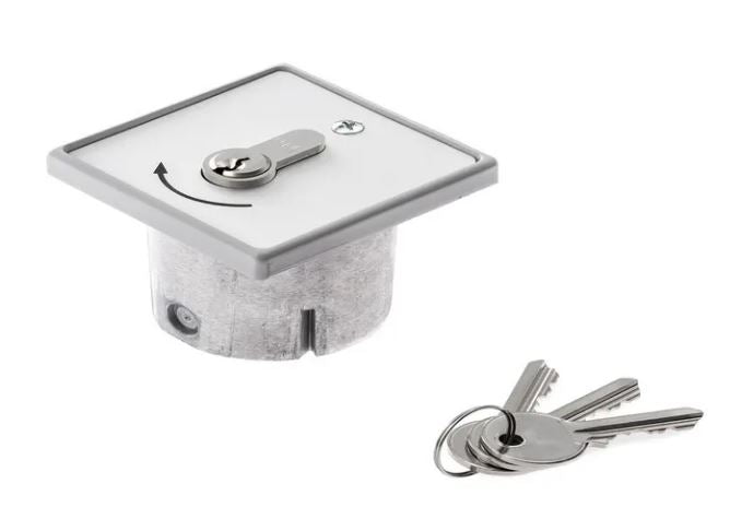 Assa abloy key-switch, a square panel with keyhole,  screw and black arrow pointing right,  3 keys by the side on a keyring, on a white background.