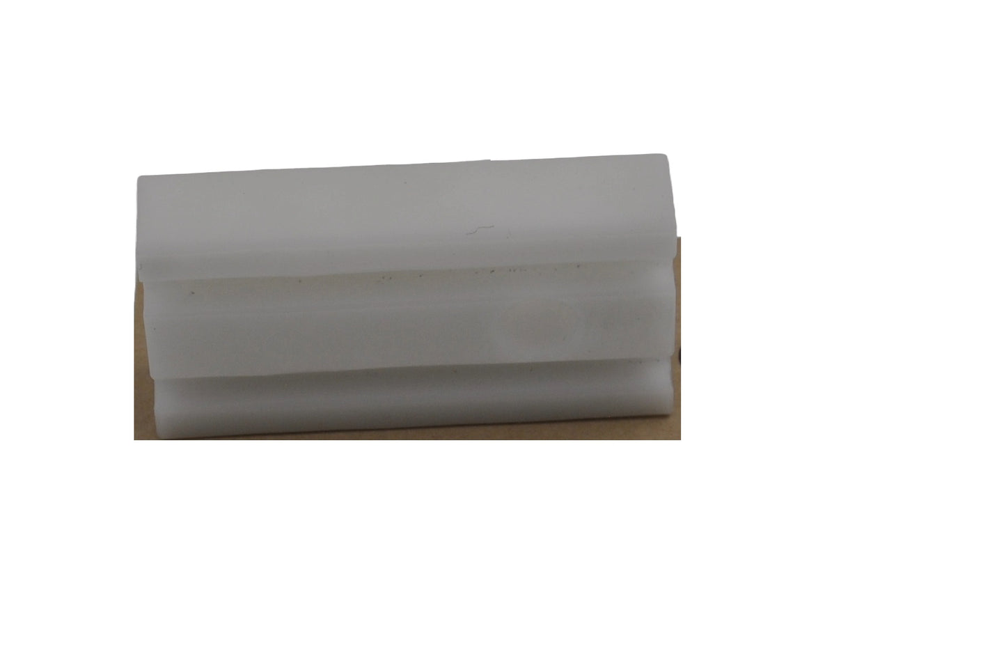 A view of a Besam breakout shoe which consists of a rectangular piece of plastic.  On a white background.